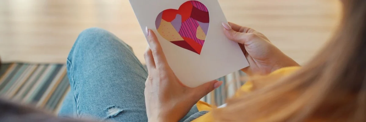 Woman holding a card with a heart cutout