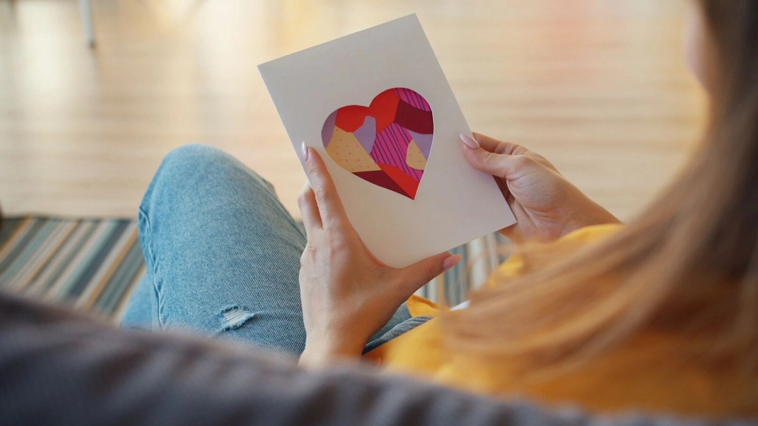 Woman holding a card with a heart cutout
