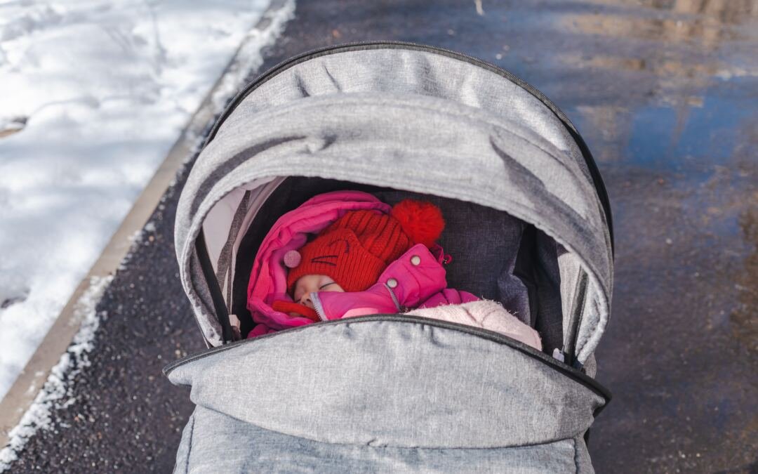 Baby anziehen im Winter: So bleibt es im Kinderwagen kuschelig warm